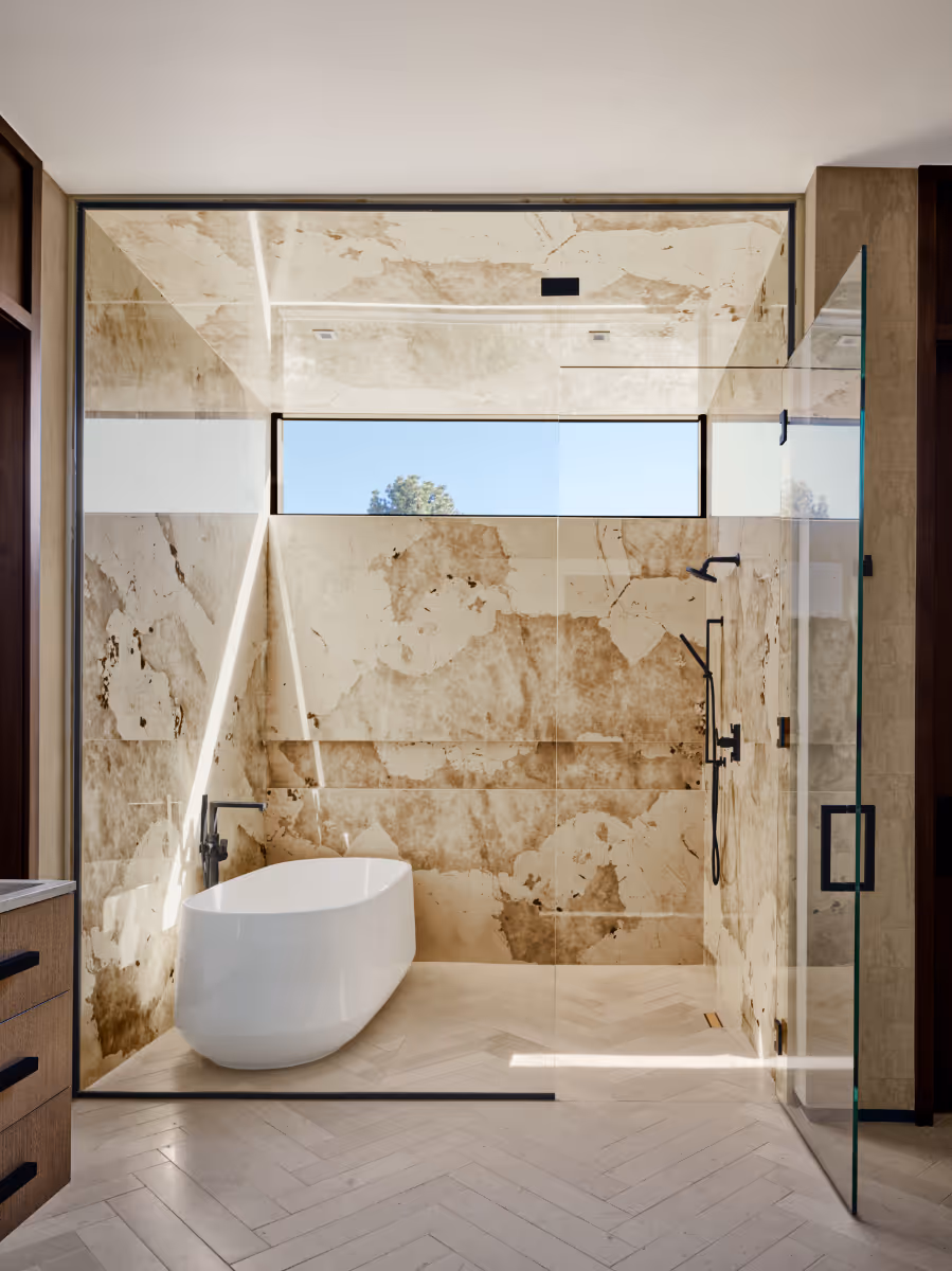 Stone clad shower with a floating bathtub in a modern new home in Sedona by The Ranch Mine