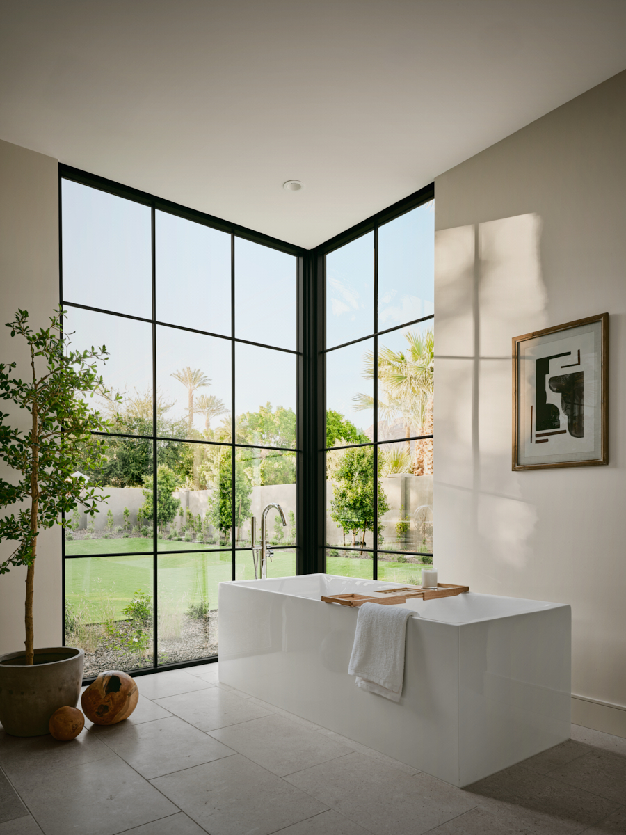 Primary bath with freestanding tub and soft light, privacy screened from the street, by The Ranch Mine