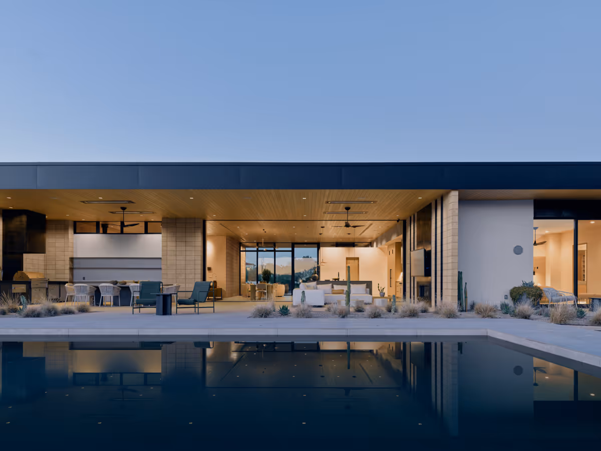 pool and indoor outdoor living at twilight  at Full Circle, a multigenerational new build compound in Paradise Valley, Arizona by The Ranch Mine
