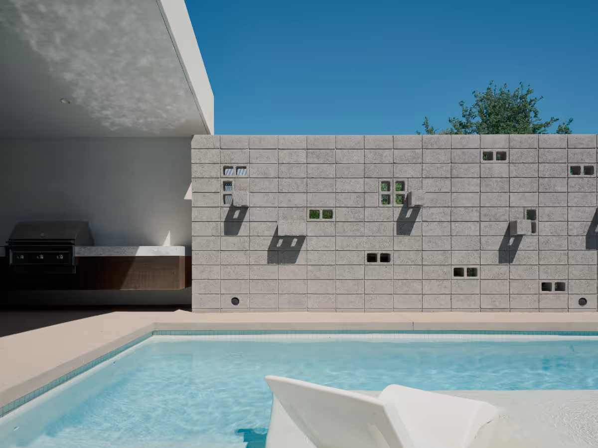 a modern offset gable house in Phoenix Arizona for an artist with concrete block and white stucco and a courtyard pool. intricate block detail