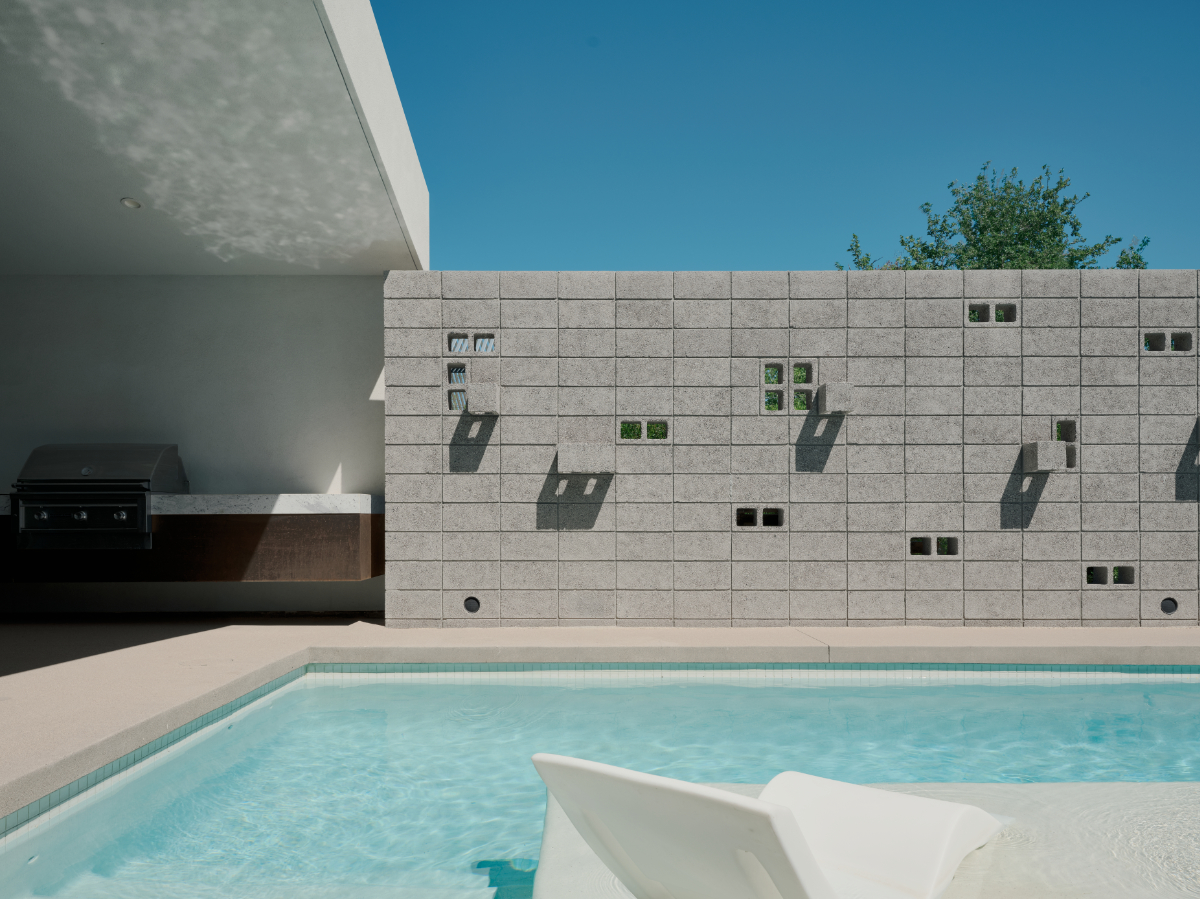 a modern offset gable house in Phoenix Arizona for an artist with concrete block and white stucco and a courtyard pool. intricate block detail