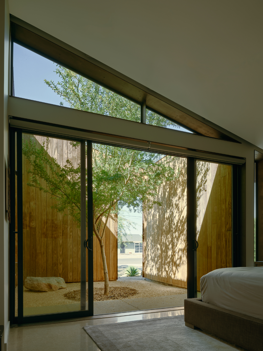 a bedroom courtyard with wood siding and a tree