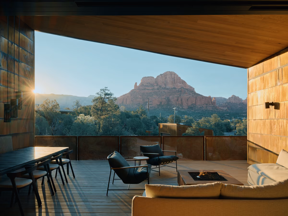 Deck at sunrise with a dining table, fire pit and an open view to a Twin Buttes