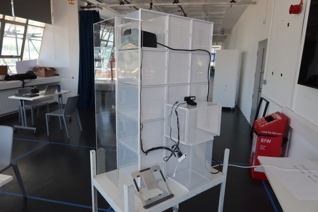 The backend of the store showing a laptop stand and webcam wired to the print machine.