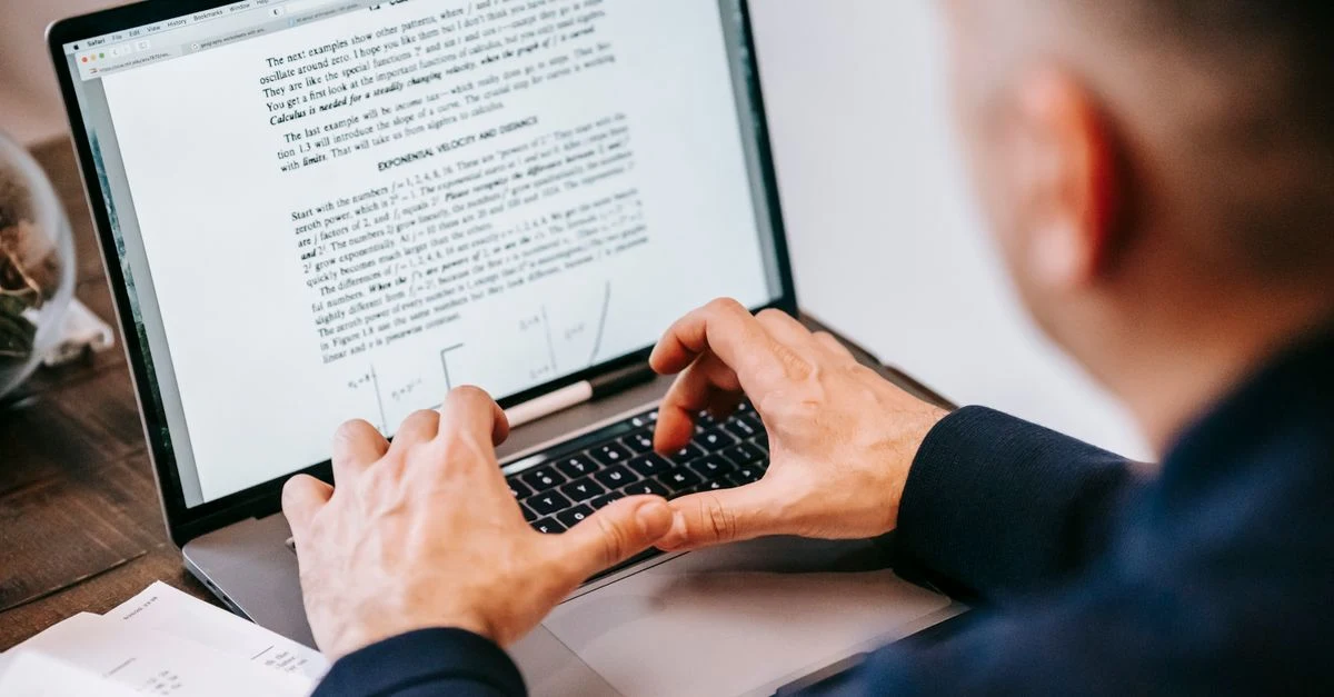 Person typing on laptop displaying text document, demonstrating B2B content writing best practices.