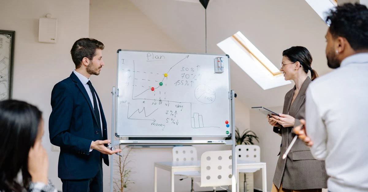 Business team discussing enterprise SEO goals on whiteboard during office planning meeting.