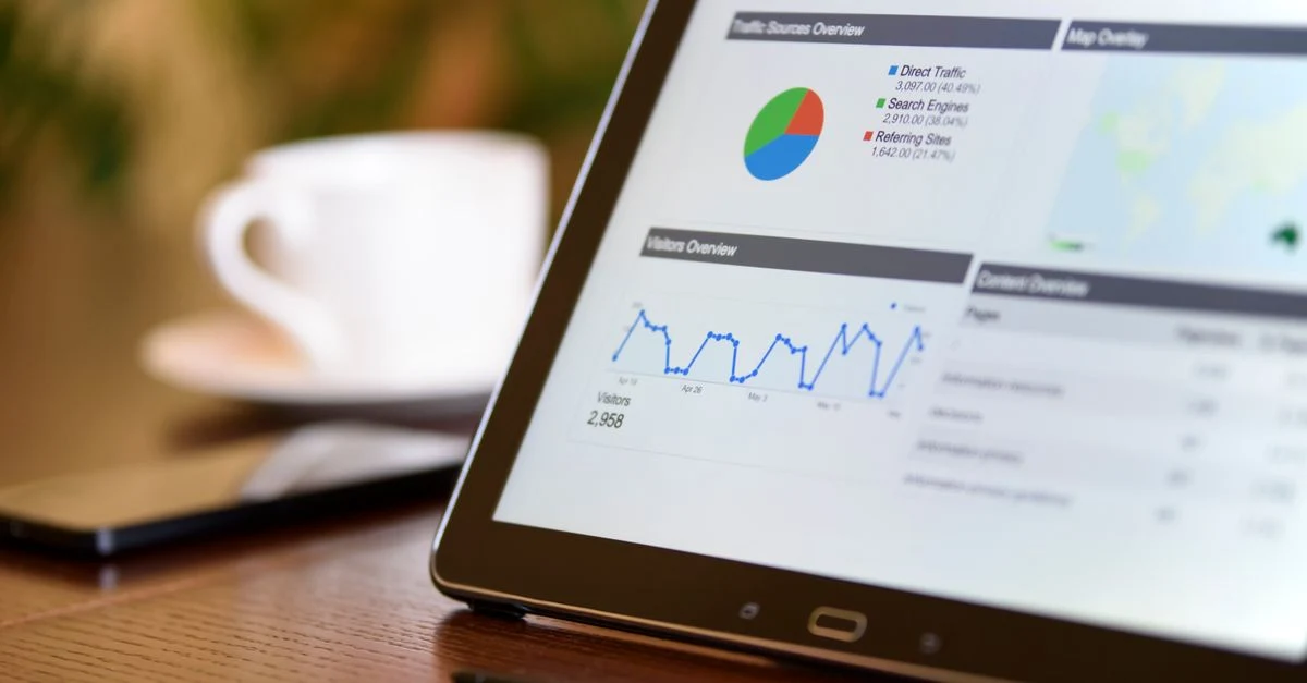 Tablet displaying analytics dashboard with pie chart and line graph tracking enterprise SEO goals performance metrics.