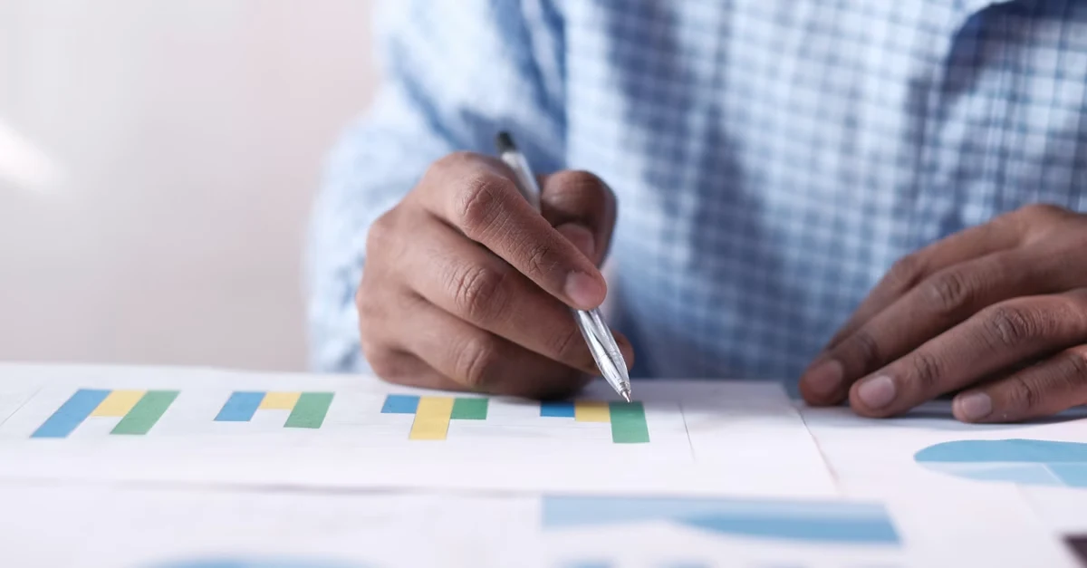 Person analyzing colorful bar charts and data visualizations to establish enterprise SEO goals for business strategy.