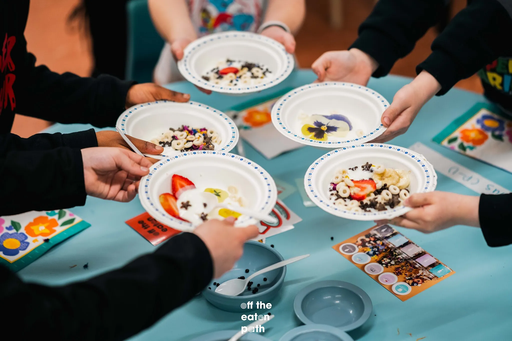 Students hold decorated yogurt bowls during the Taste Lab school workshop.