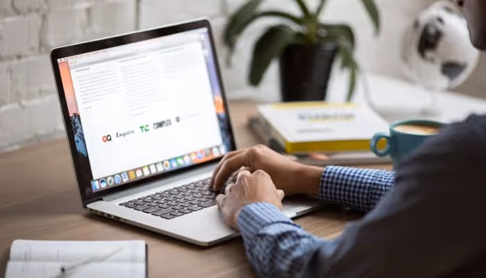 Person researching employer information at desk online