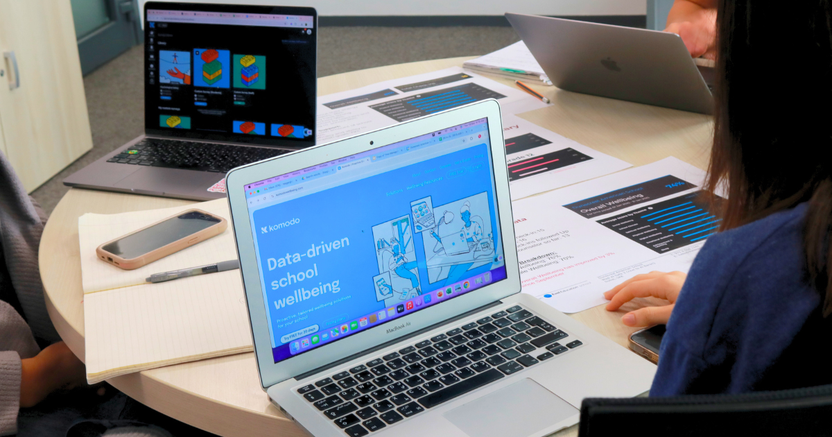 A laptop open on a desk with the Komodo Wellbeing website open