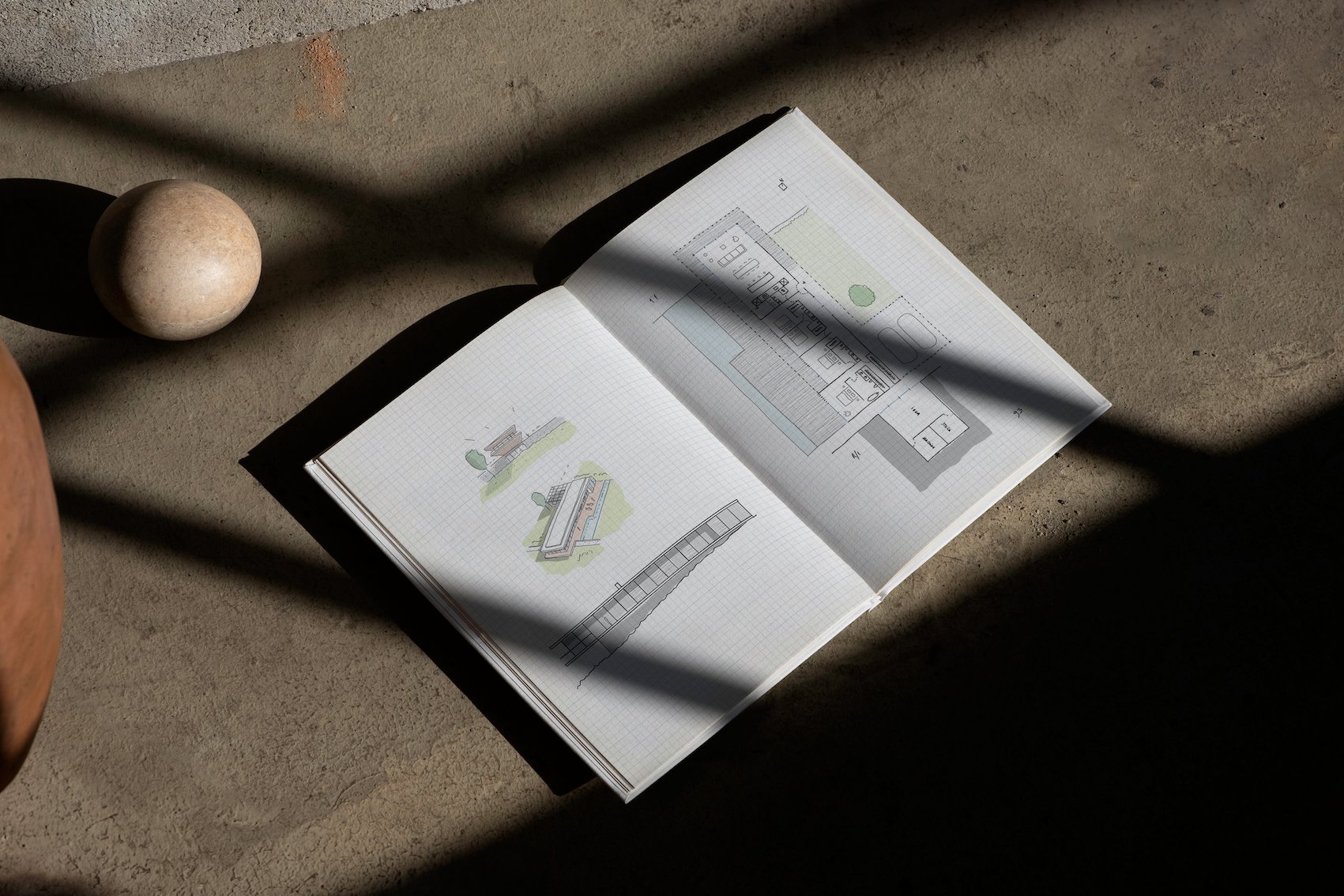 The Mima Book open, with houses drawn on grid paper