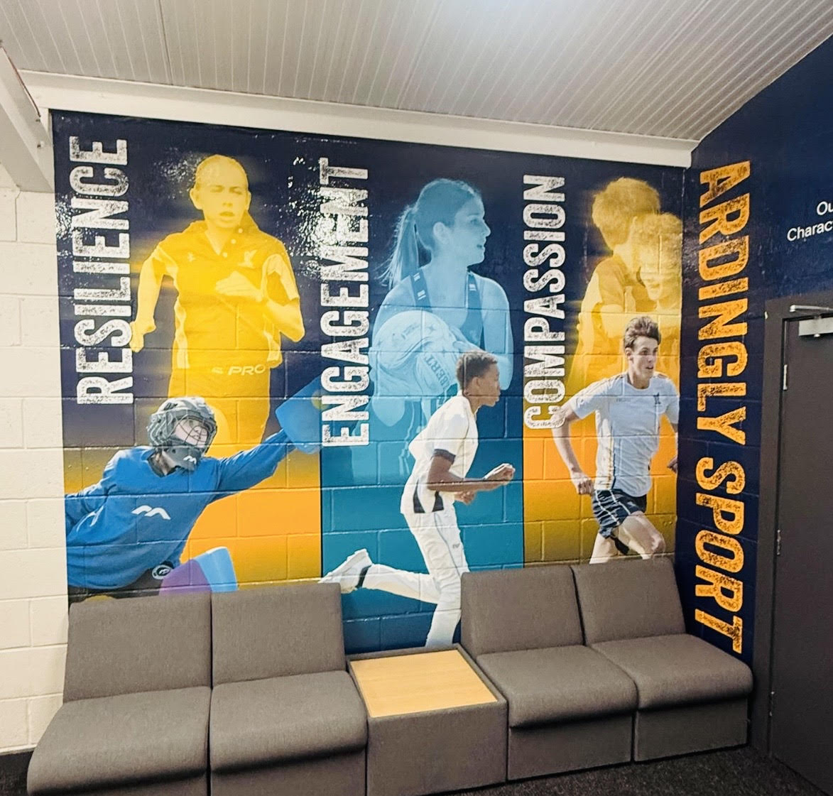 Ardingly College sports hall wall graphic showing the values Resilience, Engagement and Compassion.