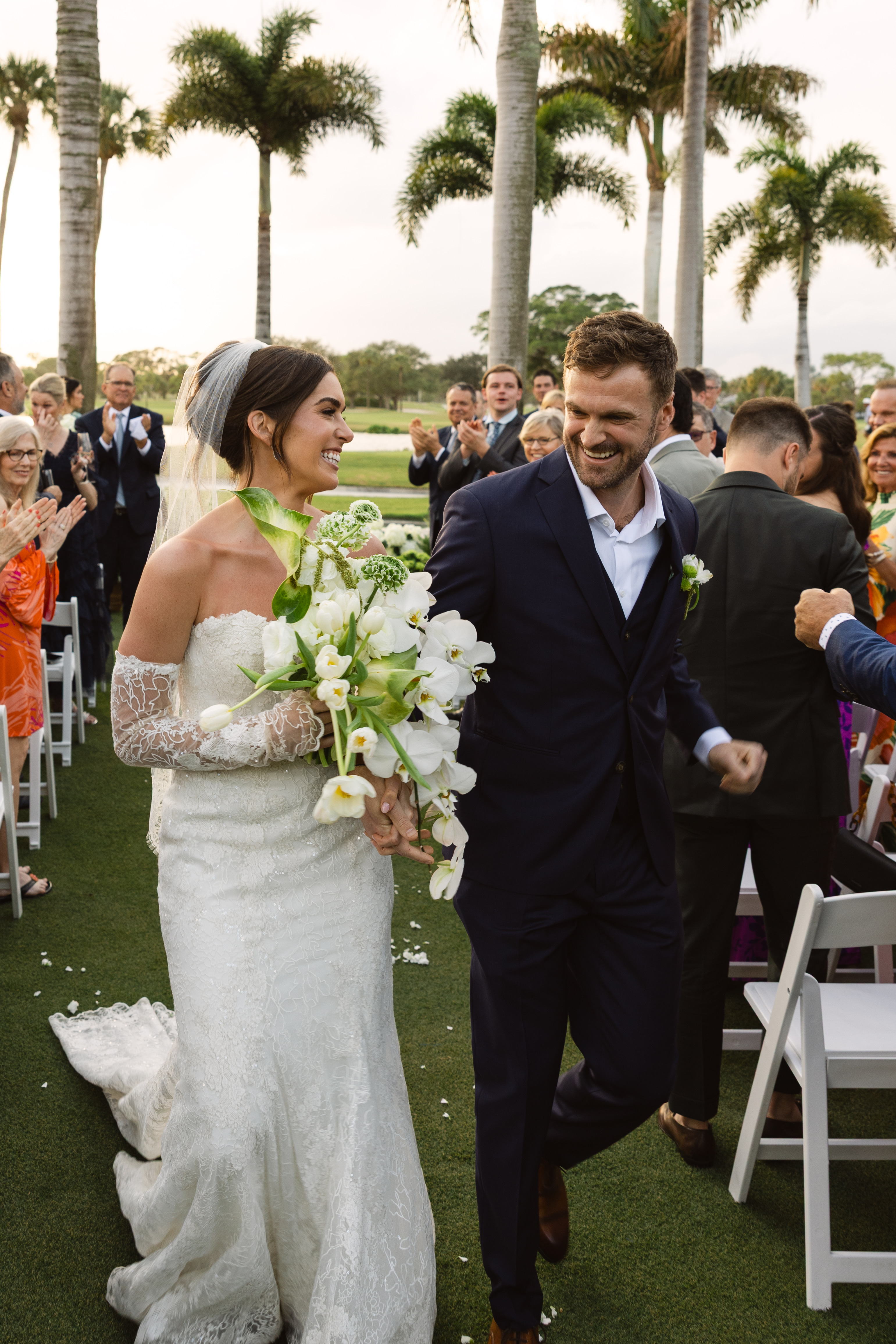 Newly married couple celebrating as they walk down the aisle after their ceremony.