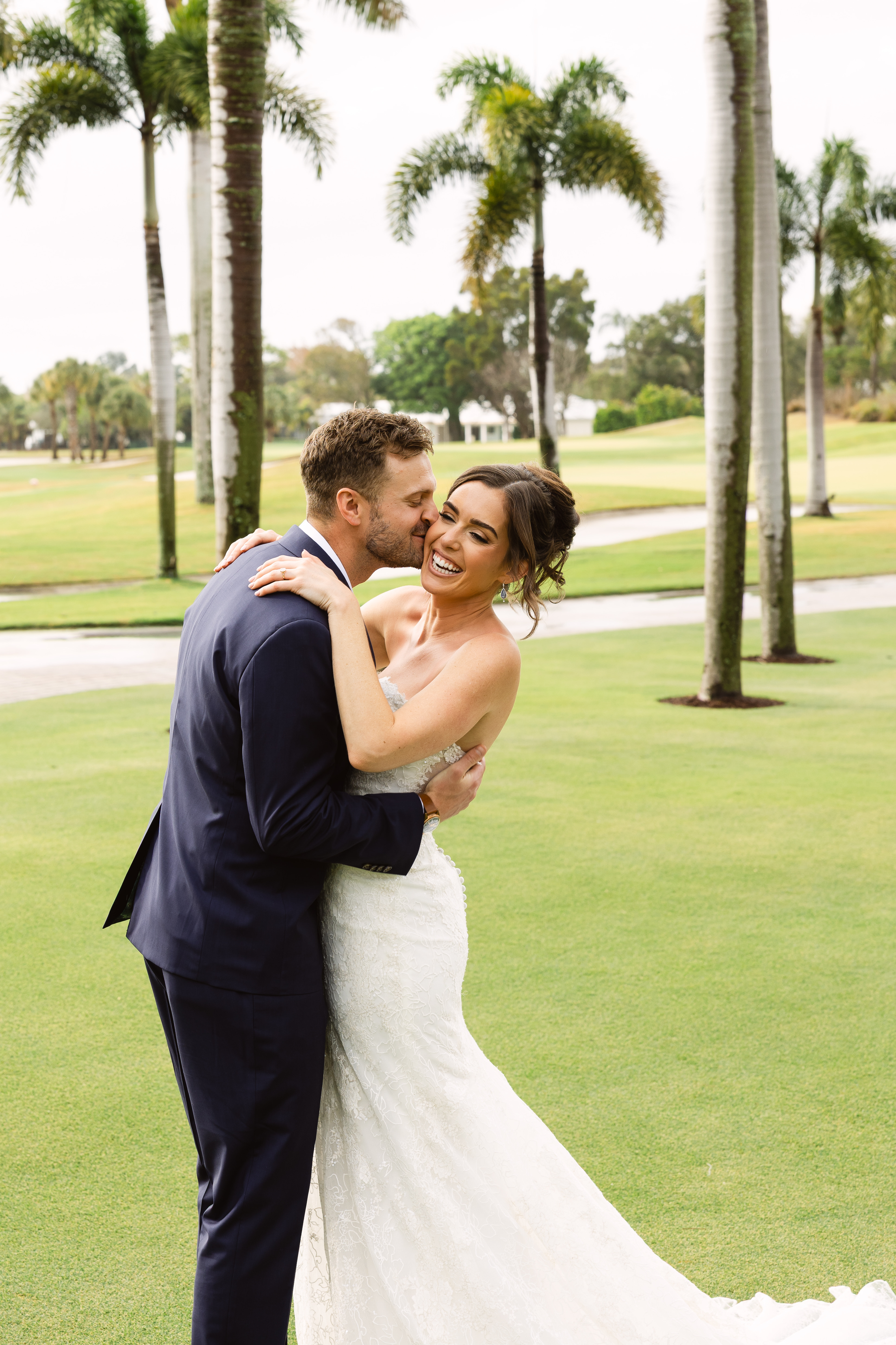 Bride and groom holding hands on the lawn at Turtle Creek Country Club.