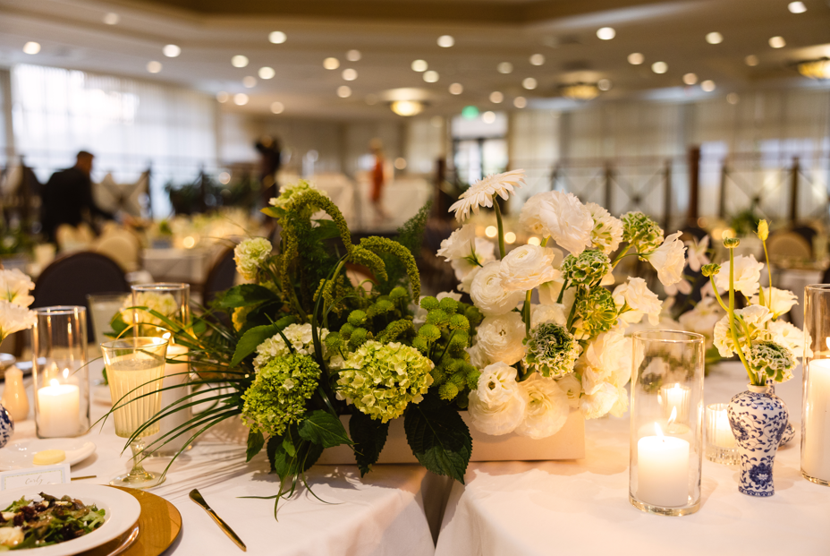 Wedding reception décor featuring white flowers and candlelit tables at Turtle Creek Country Club.