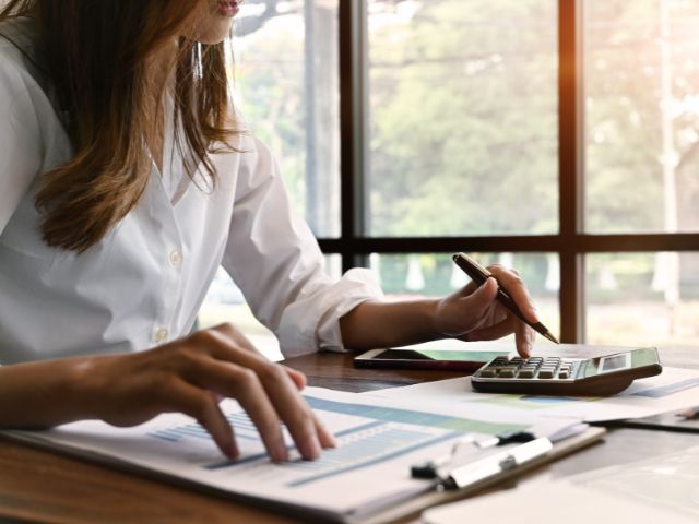 Femme qui fait des calculs pour élaborer une stratégie financière écoresponsable