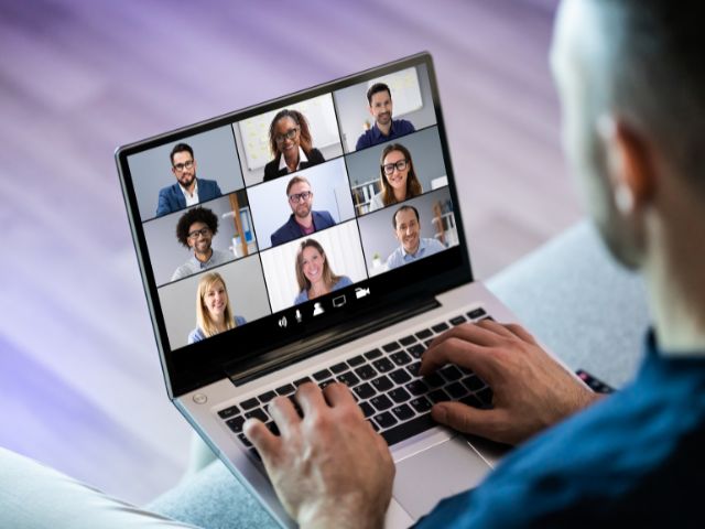 Personne devant un écran d'ordinateur en visioconférence avec 9 autres collaborateurs