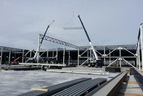 Cranes hoisting girders into place during the construction of the Amazon Distribution Center in Patterson, CA.