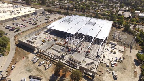 Meta Bulding under construction with cranes lifting roof sections into place.