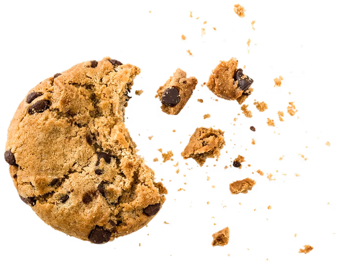 Chocolate chip cookie with a bite taken out and scattered crumbs on a black background.