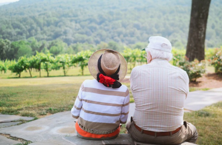 Older couple sitting on a stone ledge, enjoying a serene outdoor moment in Central Ohio