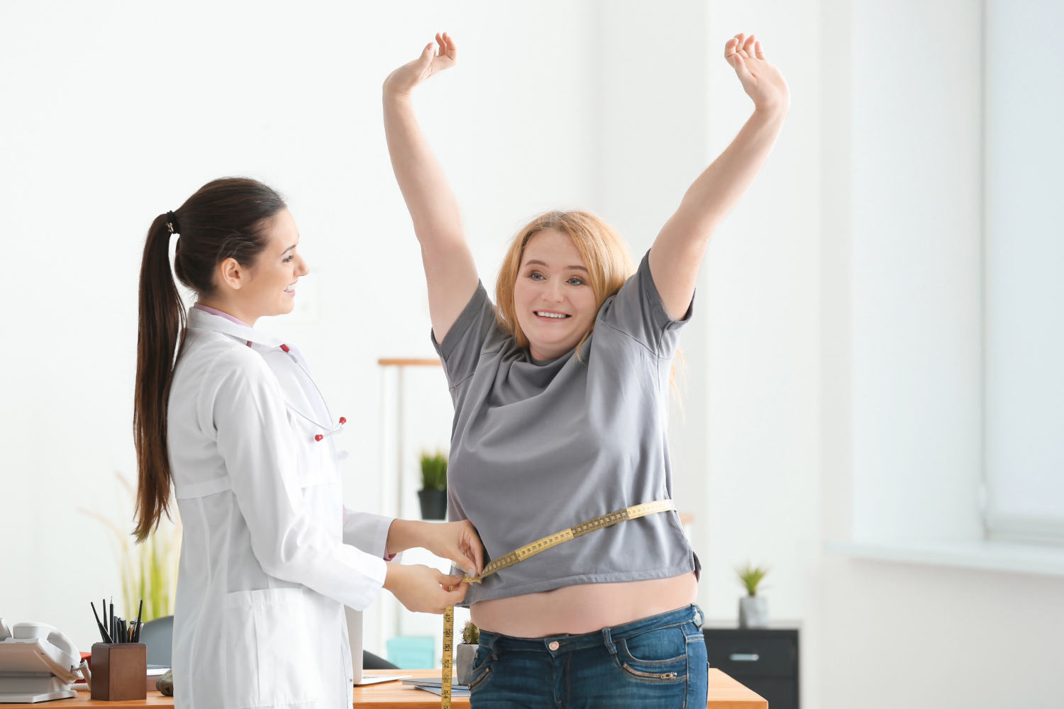 Woman celebrating weight loss with doctor.
