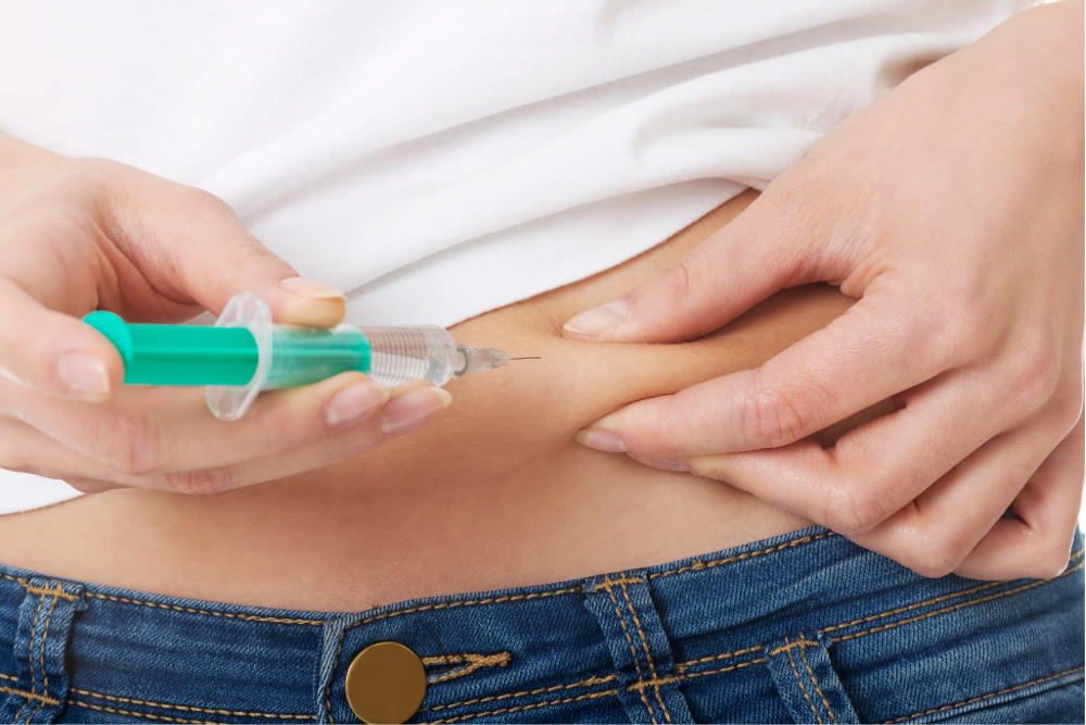 Person injecting insulin into abdomen