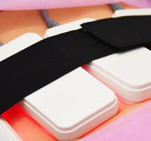 LED light therapy pads secured with a black strap.