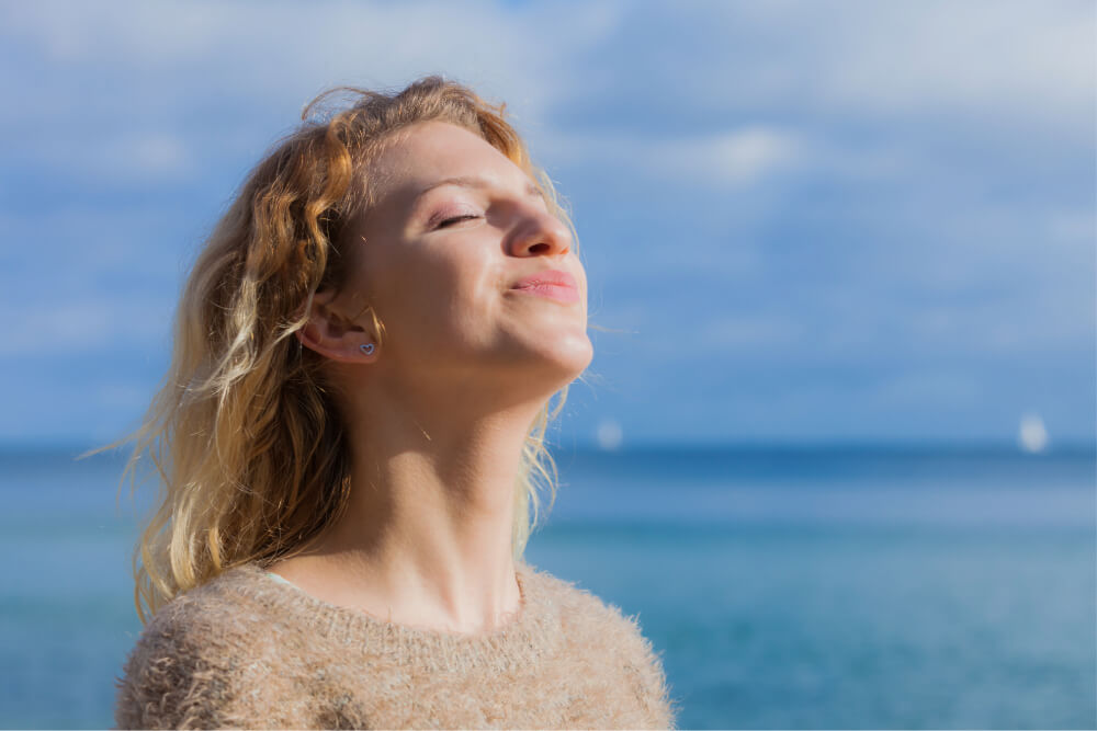 Woman enjoying ocean breeze.