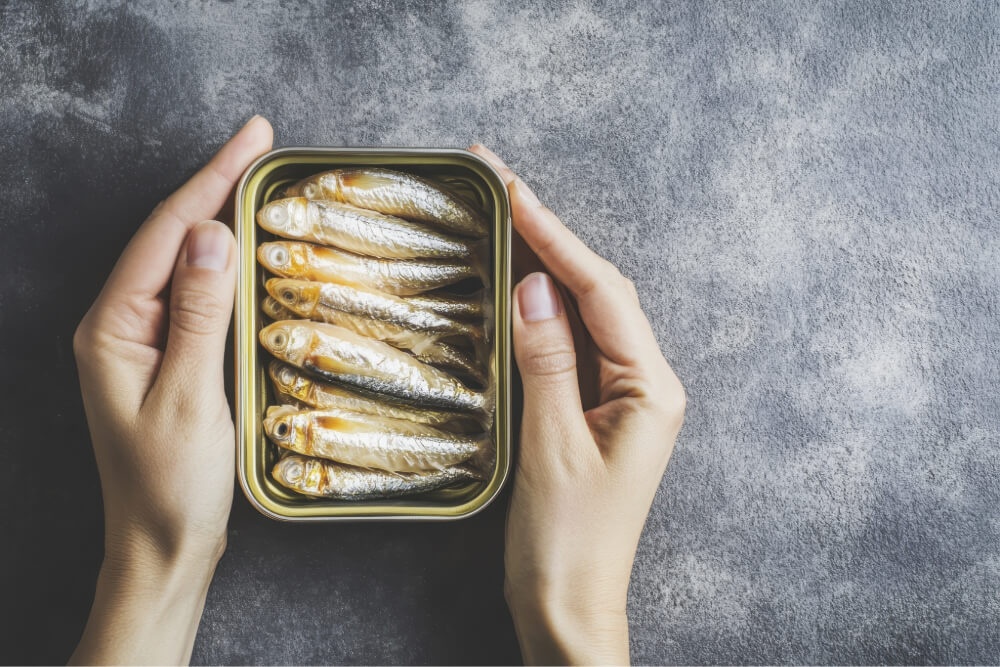 Hands holding tin of sardines