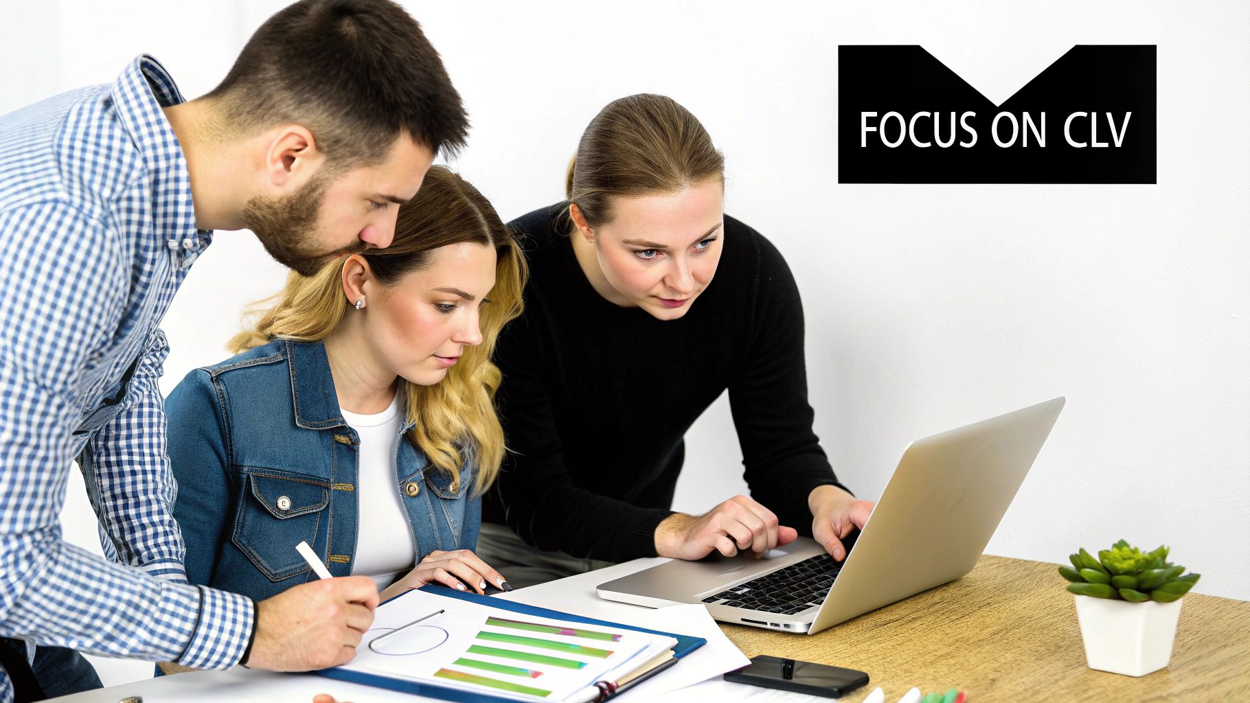 Business team analyzing customer lifetime value data charts on laptop and documents together