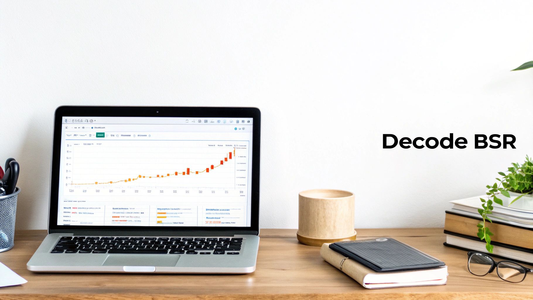 A laptop displaying a sales performance graph on a wooden desk with books and office items.