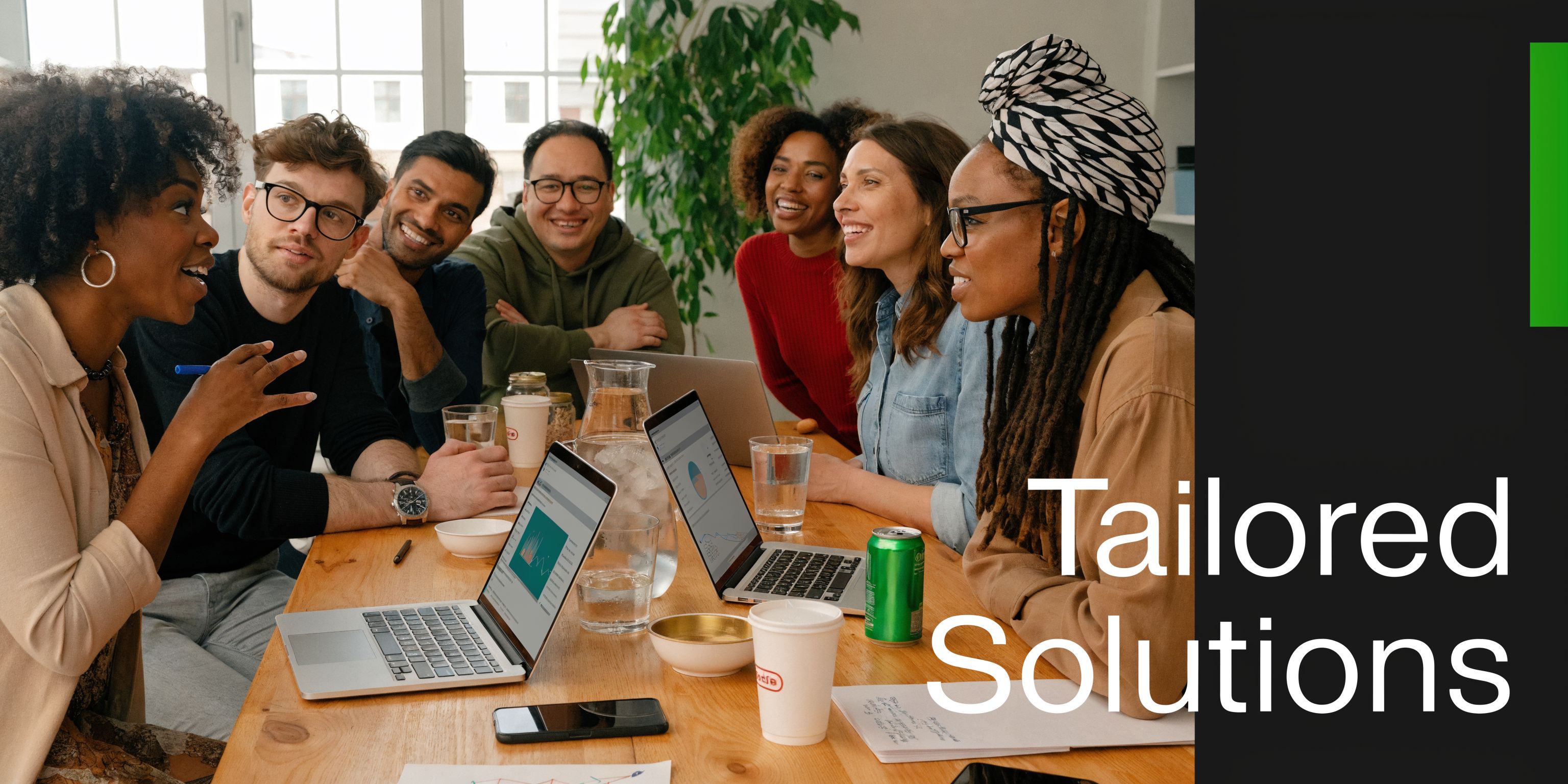 A diverse team of professionals collaborating around a large wooden table during an office strategy meeting.