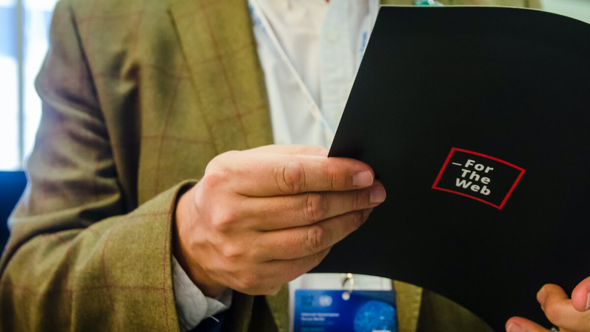 Close up photo of man holding Contract for the Web document