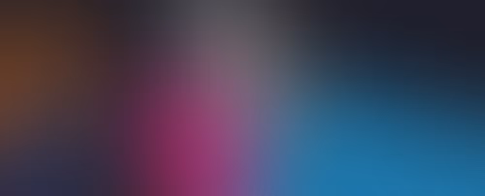 Abstract blurred background with gradient colors blending from brown and pink to blue and black.