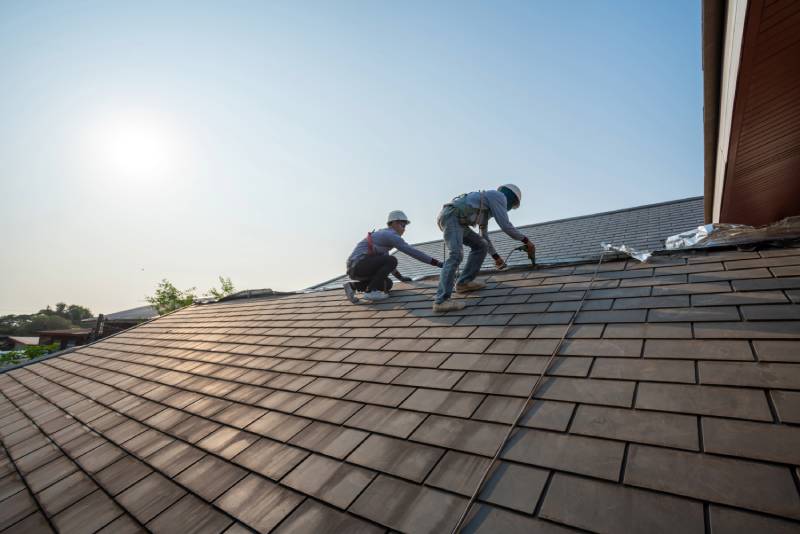 Roofers working on shingle roof.