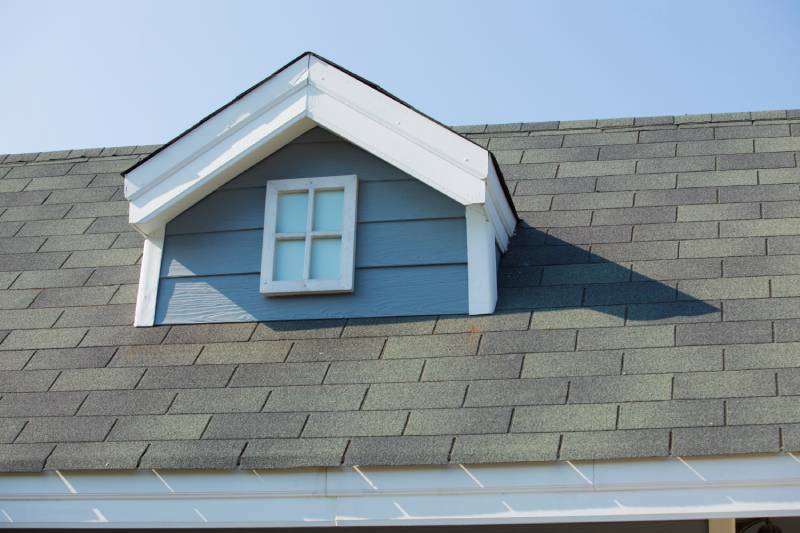 Dormer window on shingled roof.