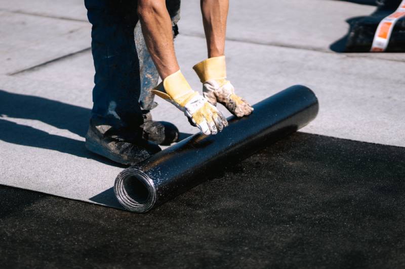 Worker installing roofing material