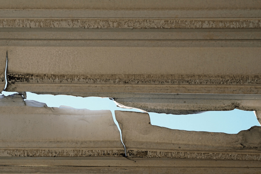 Damaged metal roof with large hole.