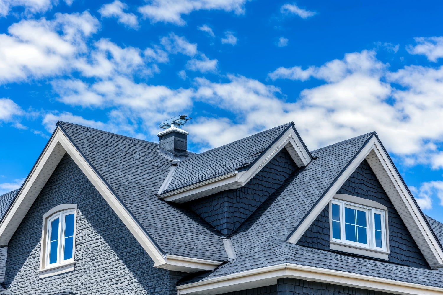 Gray shingled roof against blue sky.