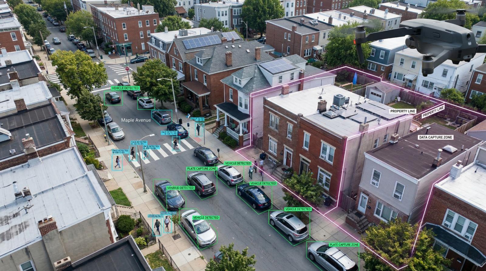 Aerial view of a city street showing a surveillance drone monitoring a residential neighborhood with AI overlays identifying vehicles, pedestrians, and property boundaries on Maple Avenue