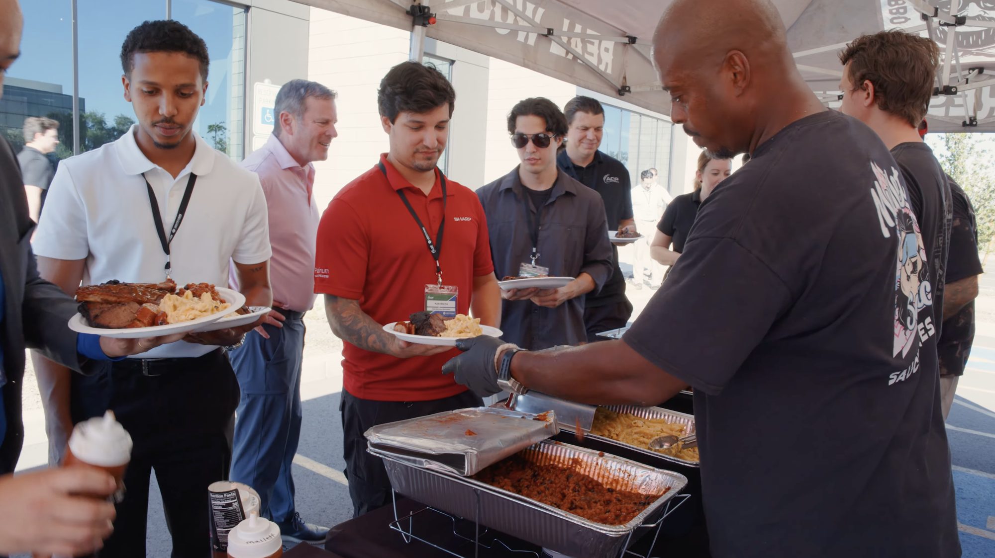 ACP team members and guests line up for barbecue with Sharp at the new Chandler facility