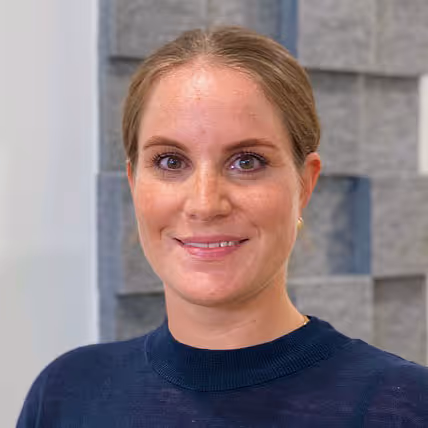 Portrait Ärztin Katharina Feigl mit hintergebundenen blonden Haaren, lächelt freundlich
