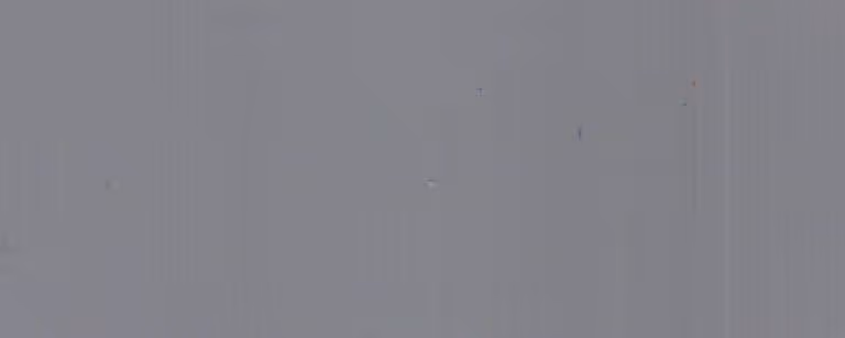 Close-up view of a smooth, light gray metal surface with subtle texture and faint vertical lines.