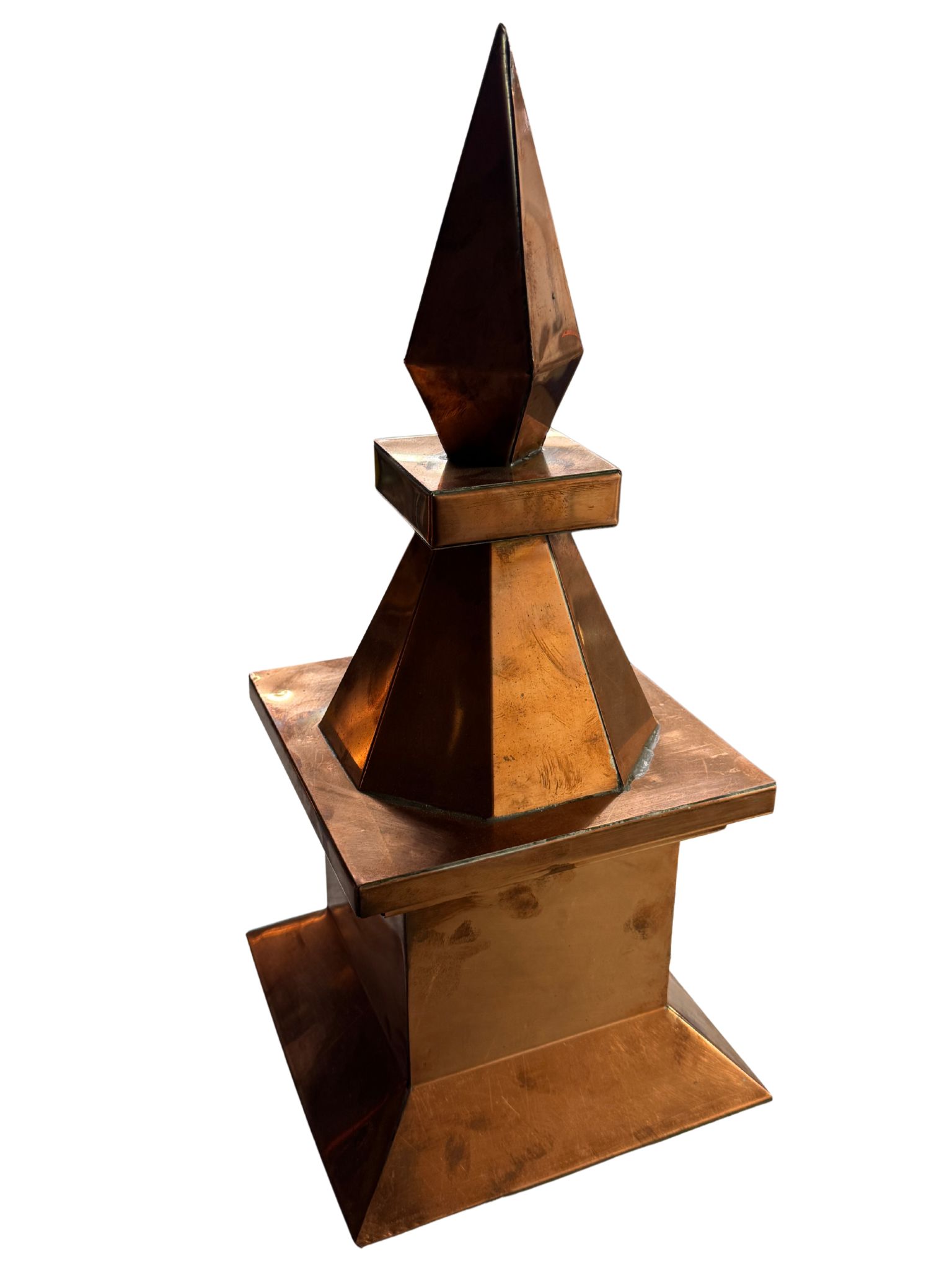 Copper-colored metal finial with a square base, tapered middle, and pointed top.