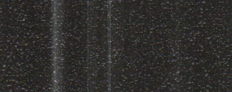 Close-up of dark metallic surface with fine textured crinkles and subtle vertical streaks.