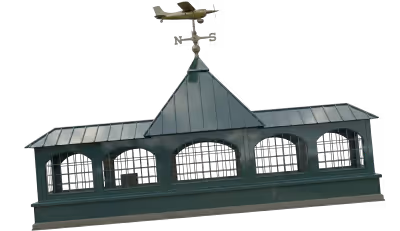 Decorative green metal cupola with arched vents and an airplane-shaped weather vane on top.