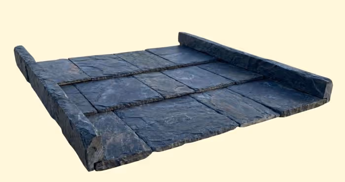 Rectangular dark gray stone slabs arranged flat with raised edges on three sides.