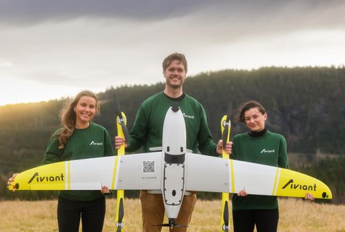 Three members of the Aviant-team holding a drone